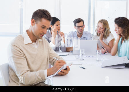 Casual businessman taking notes during meeting Stock Photo