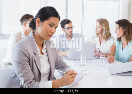 Casual businesswoman taking notes during meeting Stock Photo