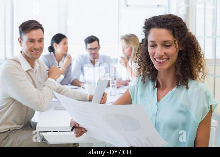 Casual businesswoman reading document during meeting Stock Photo