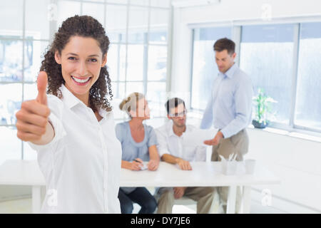 Casual happy businesswoman showing thumbs up to camera Stock Photo