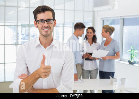 Casual businessman giving thumbs up to camera Stock Photo