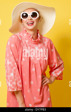 Short blond hair woman,Caucasian female model posing in studio against yellow background, a vintage fashion concept Stock Photo
