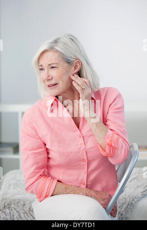 Ear pain in an elderly person Stock Photo