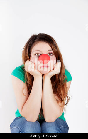 Young woman with clown nose, with a sad expression Stock Photo