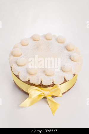 Simnel cake with basic marzipan decoration with a yellow ribbon sprinkled with icing sugar/powdered sugar,portrait (17 of 35) Stock Photo