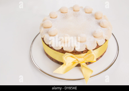 Simnel cake with basic marzipan decoration with a yellow ribbon round it sprinkled with icing sugar/powdered sugar (18 of 35) Stock Photo