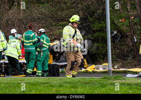 Queenswood Drive, Leeds West Yorkshire UK 9th April 2014. Emergency services attend an incident at around 1400 hours in which a vehicle overturned in a busy suburban street. Two persons were cut free from the vehicle which ended up on its roof in woodland at the side of the road in the Becketts Park LS6 area and removed from the scene by ambulance. The West Yorkshire Air Ambulance also attended the scene but was not used to transport casualties. Another vehicle, a yellow Seat Ibiza, which was seen to be damaged was also parked nearby. Credit:  Ian Wray/Alamy Live News Stock Photo