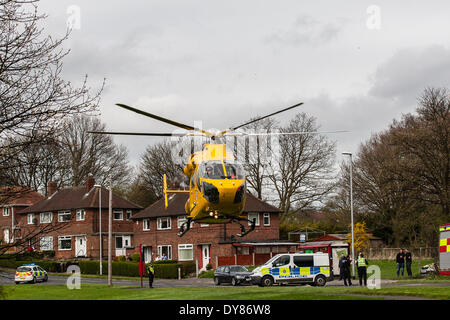 Queenswood Drive, Leeds West Yorkshire UK 9th April 2014. Emergency services attend an incident at around 1400 hours in which a vehicle overturned in a busy suburban street. Two persons were cut free from the vehicle which ended up on its roof in woodland at the side of the road in the Becketts Park LS6 area and removed from the scene by ambulance. The West Yorkshire Air Ambulance also attended the scene but was not used to transport casualties. Another vehicle, a yellow Seat Ibiza, which was seen to be damaged was also parked nearby. Credit:  Ian Wray/Alamy Live News Stock Photo