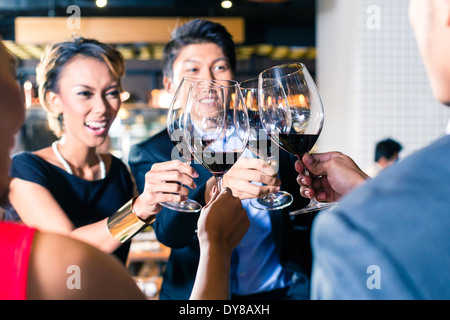 Asian friends clinking glasses Stock Photo