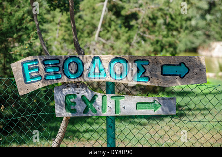 Plank with exit sign on english and greece language Stock Photo
