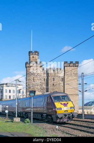 East coast train with  Flying Scotsman logo passes Newcastle keep or castle north east England UK Stock Photo