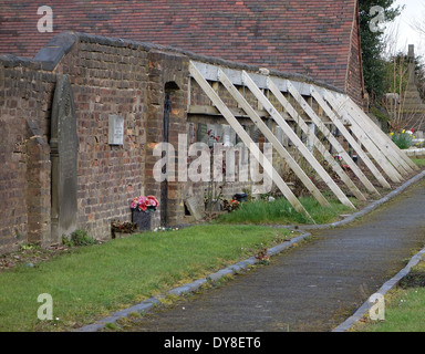 Wooden Buttressing Supporting an Unstable Wall, St Michaels Churchyard, Brierley Hill, West Midlands, England, UK Stock Photo