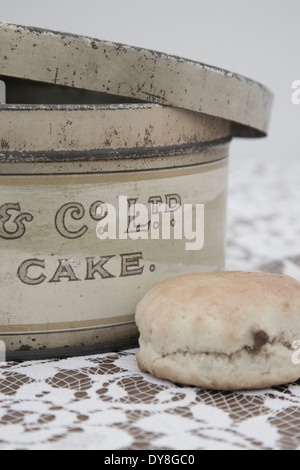 Vintage Cake Tin and a scone on a flora tablecloth Stock Photo