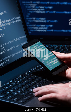 Hacker using laptop. Lots of digits on the computer screen. Stock Photo