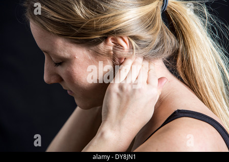 Young woman has neck pain, holding his neck vertebrae Stock Photo