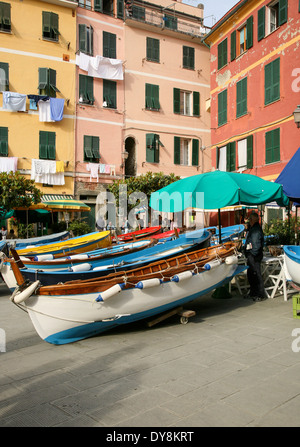 Boats docked in front of restaurant on the street in the colorful, old,  fishing village of Vernazza, Italy. Stock Photo