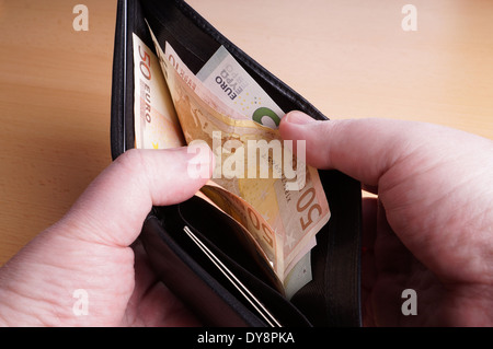 male hands opening wallet full of Euro bank notes Stock Photo