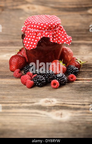 Strawberry jam in a jar on wooden board Stock Photo