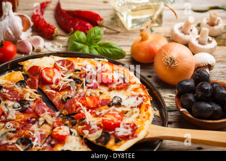 Taking slice of homemade pizza Stock Photo