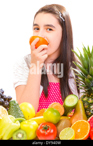 Little girl with fruits - Happy girl with fruits assortment on the table. Stock Photo