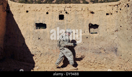 US Army Staff Sgt. Dennis Speek with the 707th Explosive Ordnance Disposal Company, places C-4 explosive charges inside a wall to destroy a Taliban safe house once used by insurgent fighters December 18, 2009 in Khost province, Afghanistan. Stock Photo