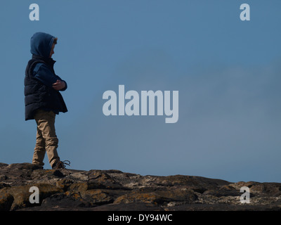 Young boy wearing a hoodie with arms folded, UK Stock Photo