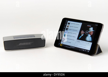 Apple iPad mini running a music app and a Bose portable bluetooth speaker Stock Photo