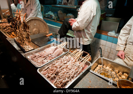 small restaurant serving food on skewers for exemple fried octopuses  at Wangfujing Snack Street, Beijing, China Stock Photo