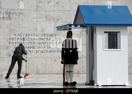 Athens, Greece. 10th Apr, 2014. A Greek soldier wipes the rainwater in front of the monument of the Unknown Soldier in Syntagma Square. Evzones perform the Changing of the Guard Ceremony at the Tomb of the Unknown Soldier in Syntagma Square in Athens, Greece on April 10, 2014. Credit:  Konstantinos Tsakalidis/Alamy Live News Stock Photo