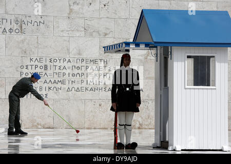 Athens, Greece. 10th Apr, 2014. A Greek soldier wipes the rainwater in front of the monument of the Unknown Soldier in Syntagma Square. Evzones perform the Changing of the Guard Ceremony at the Tomb of the Unknown Soldier in Syntagma Square in Athens, Greece on April 10, 2014. Credit:  Konstantinos Tsakalidis/Alamy Live News Stock Photo