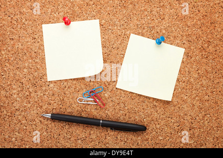 Blank postit notes on cork notice board with pen Stock Photo