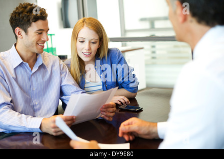 Clients going over paperwork with consultant Stock Photo