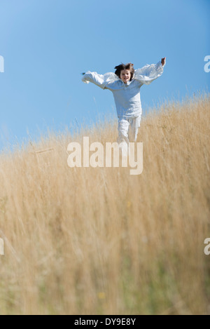 Boy running through tall grass Stock Photo