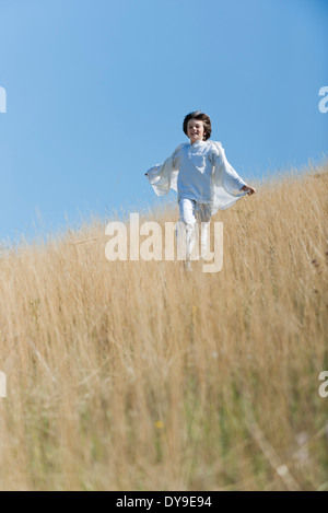 Boy running through tall grass Stock Photo