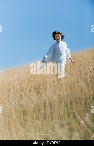 Boy running through tall grass Stock Photo