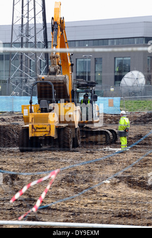 A mechanical digger and dumper truck moving excavated earth on a construction site in Scotland, UK Stock Photo