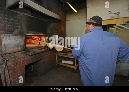 A religious Jewish man putting matzoh into the oven at the Borough Park Matzah Bakery in Brooklyn, New York Stock Photo