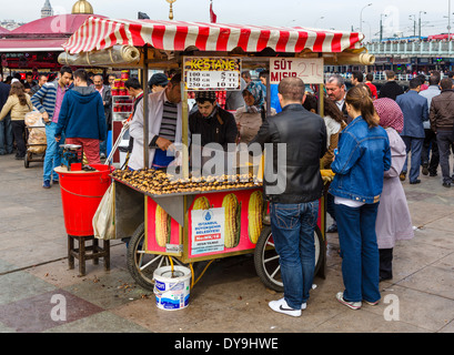 Street vendor selling corn on the cob and roasted chestnuts near the Galata Bridge in the Eminonu district, Istanbul,Turkey Stock Photo