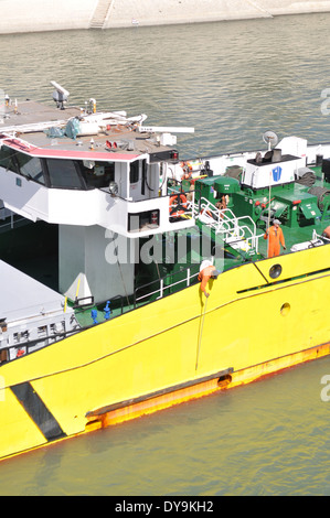 two crewmen doing maintenance on board a large river barge sailing up the river Rhone at Arles Stock Photo