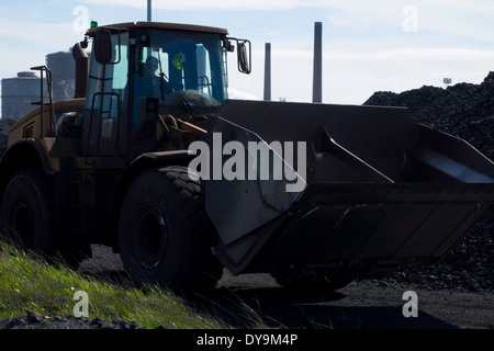 A wheeled front end bucket loader machine working in coal stocking ground of a coke oven plant Stock Photo
