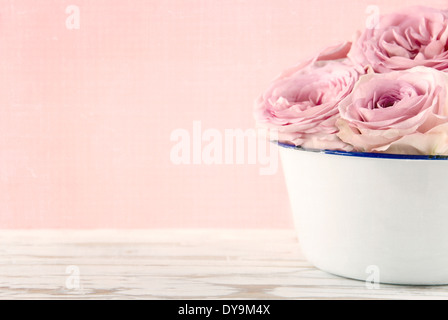 Pink roses in a white old vase on vintage white wooden background Stock Photo