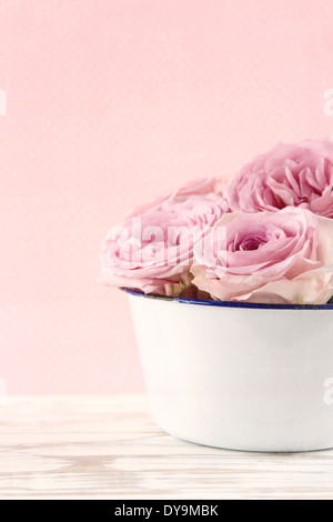 Pink roses in a white old vase on vintage white wooden background Stock Photo