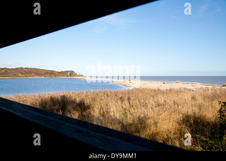 Looking out of bird hide across Benacre broard and the sea and beach, Suffolk, England. Stock Photo