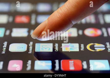 Tablet App Being Selected by a Finger on the Touchscreen, Close Up. Stock Photo