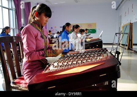 Bayan Nur, China's Inner Mongolian Autonomous Region. 10th Apr, 2014. Students learn to play yangqin, a musical instrument, at a middle school for the Mongolian ethnic group, in Bayan Nur, north China's Inner Mongolian Autonomous Region, April 10, 2014. Folk art courses such as archery, folk costumes, folk dance, wrestling were set up as selective courses for students here. © Zhi Maosheng/Xinhua/Alamy Live News Stock Photo