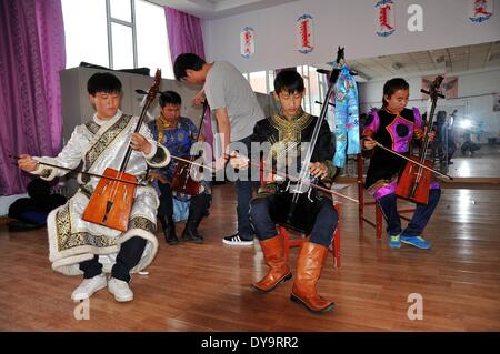 Bayan Nur, China's Inner Mongolian Autonomous Region. 10th Apr, 2014. Students learn to play Matouqin, a horse-head musical instrument, at a middle school for the Mongolian ethnic group, in Bayan Nur, north China's Inner Mongolian Autonomous Region, April 10, 2014. Folk art courses such as archery, folk costumes, folk dance, wrestling were set up as selective courses for students here. © Zhi Maosheng/Xinhua/Alamy Live News Stock Photo