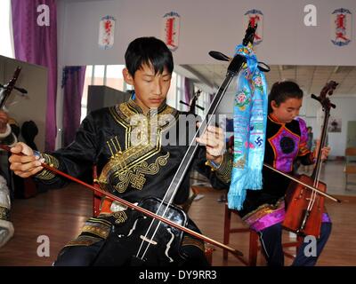 Bayan Nur, China's Inner Mongolian Autonomous Region. 10th Apr, 2014. Students learn to play Matouqin, a horse-head musical instrument, at a middle school for the Mongolian ethnic group, in Bayan Nur, north China's Inner Mongolian Autonomous Region, April 10, 2014. Folk art courses such as archery, folk costumes, folk dance, wrestling were set up as selective courses for students here. © Zhi Maosheng/Xinhua/Alamy Live News Stock Photo