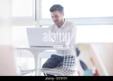 Man using laptop computer in cafe Stock Photo