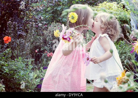 Little girl kissing her baby sister outdoors Stock Photo