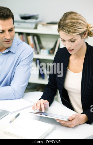 Colleagues looking down at digital tablet Stock Photo